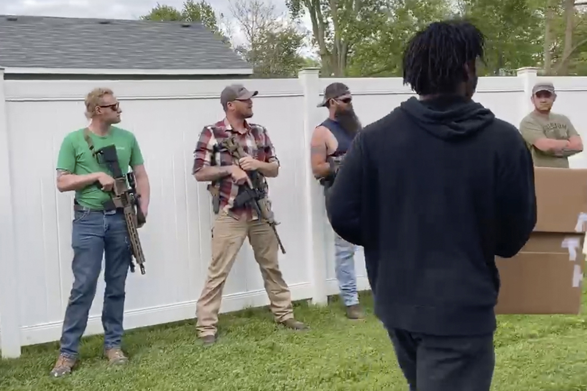 White bystanders armed with rifles watch Floyd protesters march in Indiana
